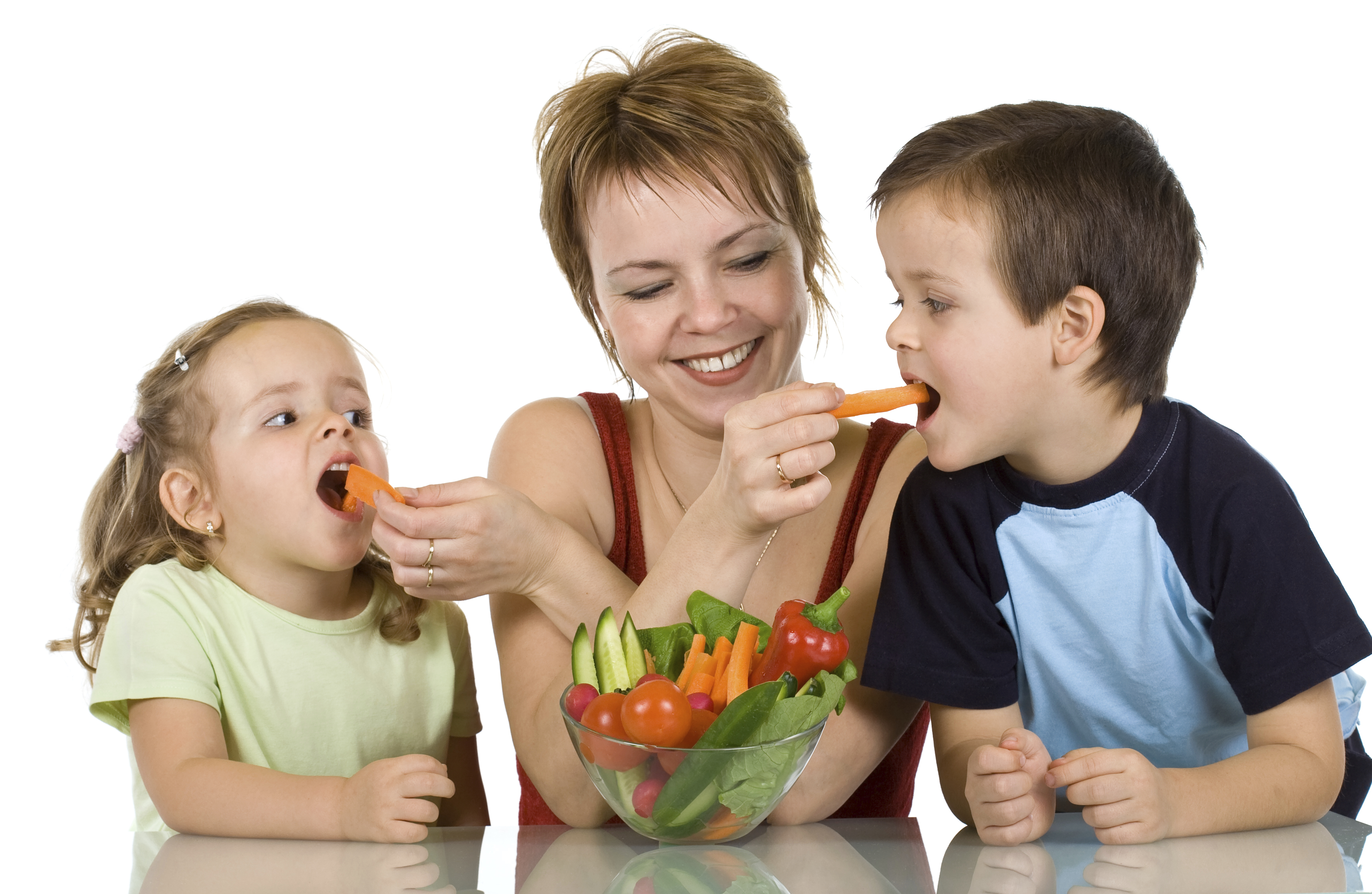 Woman feeding kids with vegetables