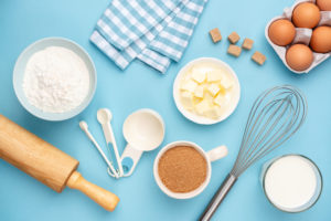 Kitchen utensils and baking ingredients on blue background. Retro style baking and cooking flat lay, table top view
