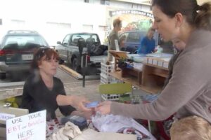 Woman using an EBT card at a farmer's market stand